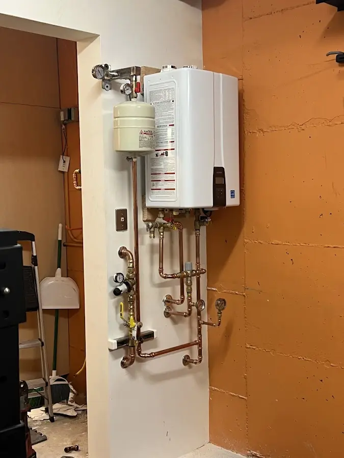 Plumbing technician inspecting water heater connections in Columbus